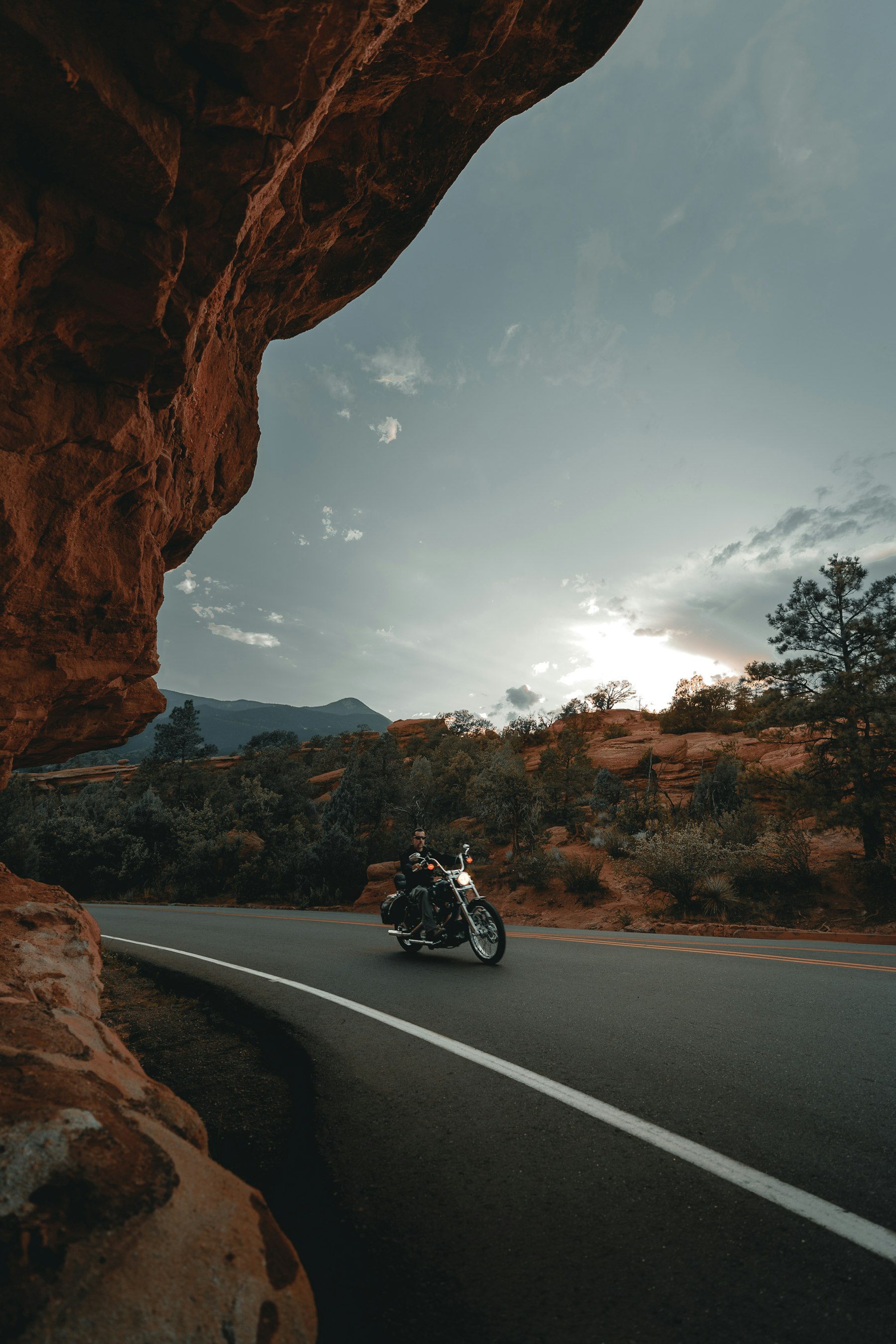 Motard sur une route au coucher du soleil